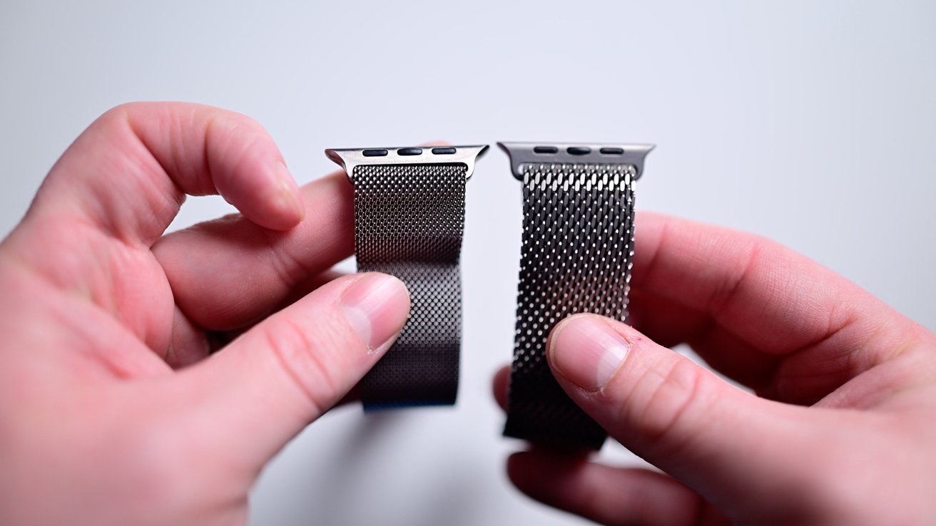 Two hands holding apple watch bands with different mesh designs against a light background.